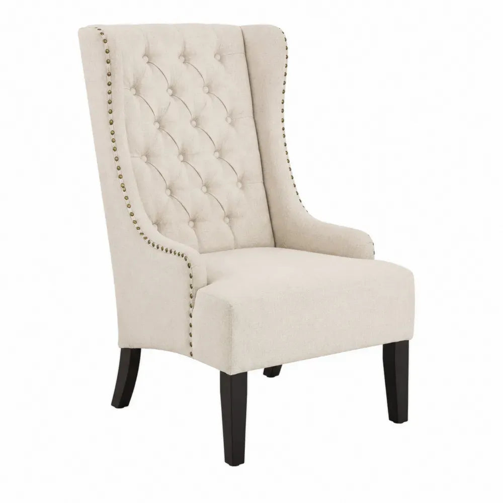 Sillón orejero tapizado en tejido color crema con respaldo capitoné y tachuelas metálicas patas de madera maciza 75 x 80 x 100 cm estilo clásico